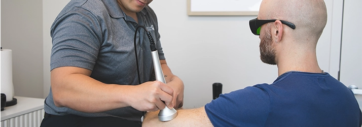 A therapist uses a soft-tissue tool on a patient’s arm.