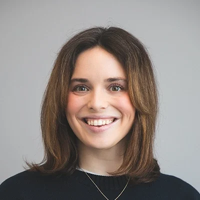 Chiropractor Katie Keelin Smiling In Front Of Grey Background